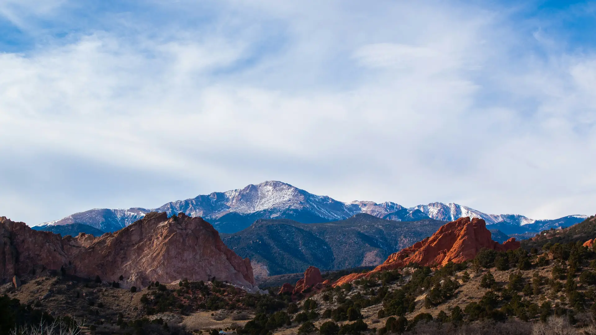 Red sandstone formations of Garden of the Gods with Pikes Peak behind them